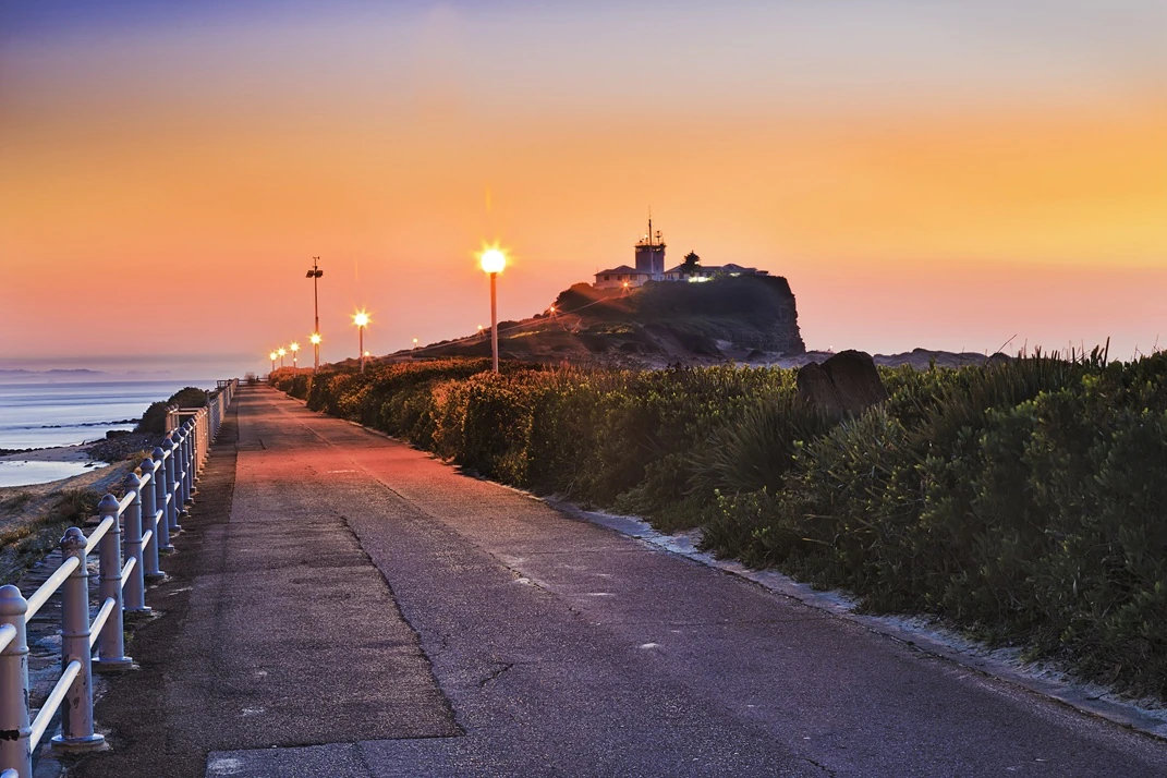 Scenic view of Nobbys Beach in Newcastle, NSW, with a pathway leading to the lighthouse