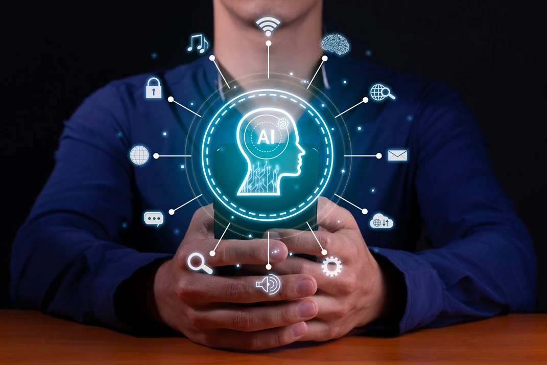 Person holding an AI personal assistant on their smartphone with a digital brain and AI icons surrounding it.